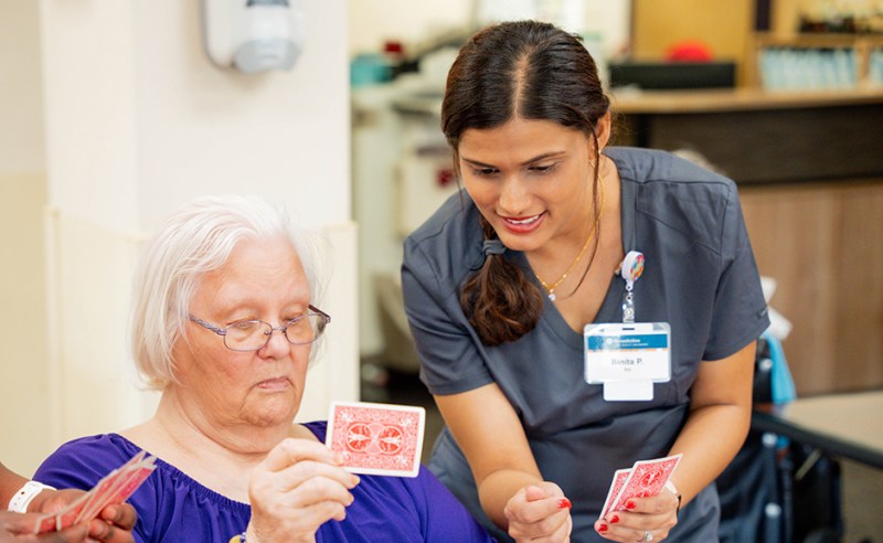 International RN Binita Poudel, right, works with residents of the New Brighton Benedictine Living Community.