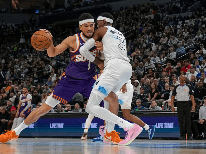 Nov 17, 2024; Minneapolis, Minnesota, USA; Phoenix Suns guard Devin Booker (1) protects the ball from Minnesota Timberwolves forward Jaden McDaniels (3) during the second quarter at Target Center.