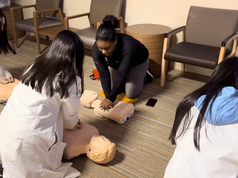 Jasmine Millon, emergency medical resident, showing participants how to perform CPR.
