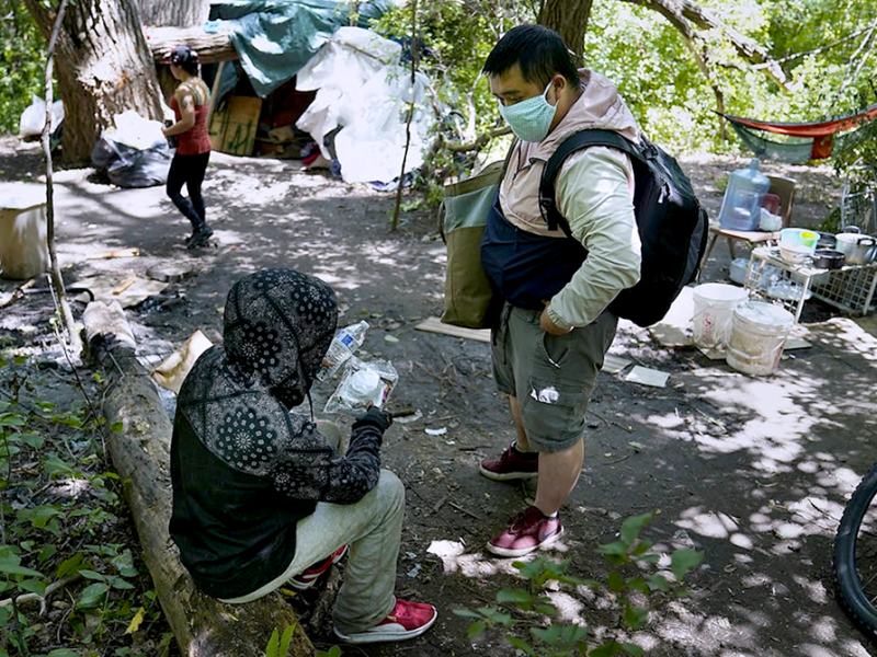 A member of a People Incorporated ARC Outreach Team, right, working with an encampment resident.