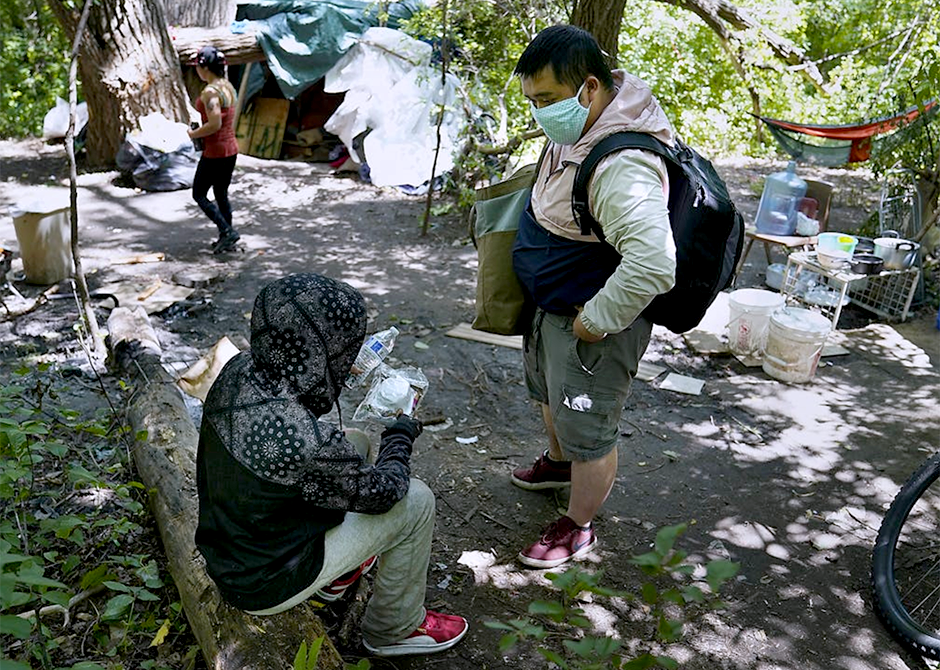 A member of a People Incorporated ARC Outreach Team, right, working with an encampment resident.