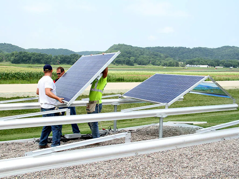 Workers install the first panels on Tri-County Electric cooperative's 74 kW community solar array in Rushford, Minnesota in 2014.