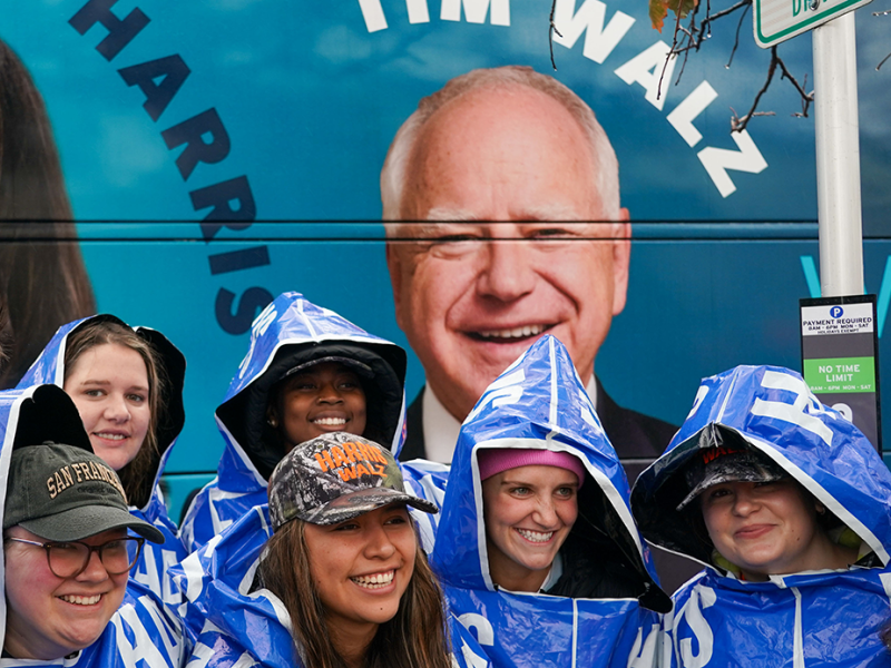 DFL volunteers posing in front of a bus depicting Vice President Kamala Harris and Gov. Tim Walz at a get out the vote kick-off tour of the state last Thursday.