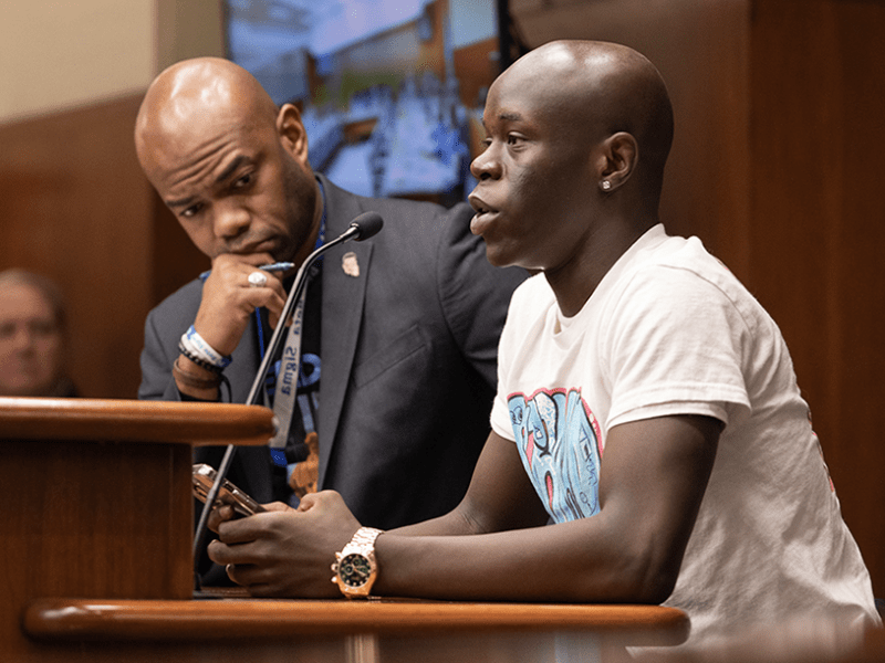 Gabriel, a high school student, testifying during a House Education Policy Committee on Monday. State Rep. Cedrick Frazier is at left.