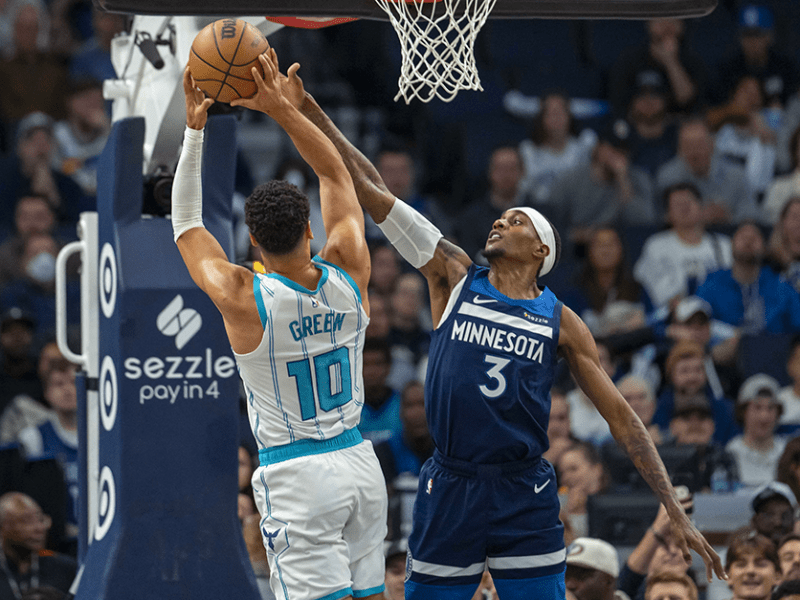 Charlotte Hornets guard Josh Green, left, attempting a shot over Timberwolves forward Jaden McDaniels, right, in the first half at Target Center on Monday.