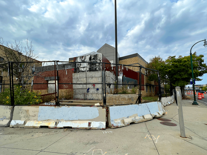 Minneapolis’ former Third Precinct Police Station at Lake Street & Minnehaha Avenue, surrounded by barricades and razor wire.