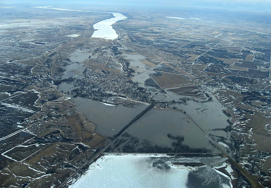 Aerial photograph showing flooding in the Traverse Gap, the former southern outlet of Glacial Lake Agassiz and the source of River Warren. Ice-covered Lake Traverse (Mde Hdakiŋyaŋ), a natural border between Minnesota (left) and South Dakota (right) is at bottom center; Big Stone Lake (Mde Iŋyaŋ Taŋka) is at top center.
