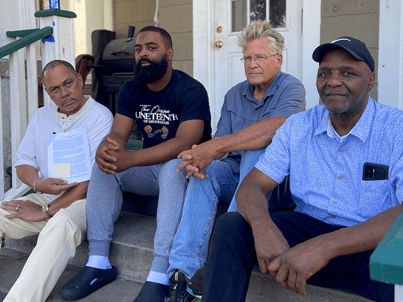 From left: Rev. Ian Bethel, Alfred Flowers Jr., Mark Anderson and Al Flowers, members of the Unity Community Mediation Team. Bethel is holding up the Memorandum of Understanding between the UCMT and the Minneapolis Police Department.
